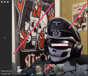 Ohpeak telegram profile pic. He is wearing a nazi uniform, skull mask, and headphones. He appears to be sitting at a desk, possibly at a gaming computer. Behind him are various nazi flags/memorabilia.